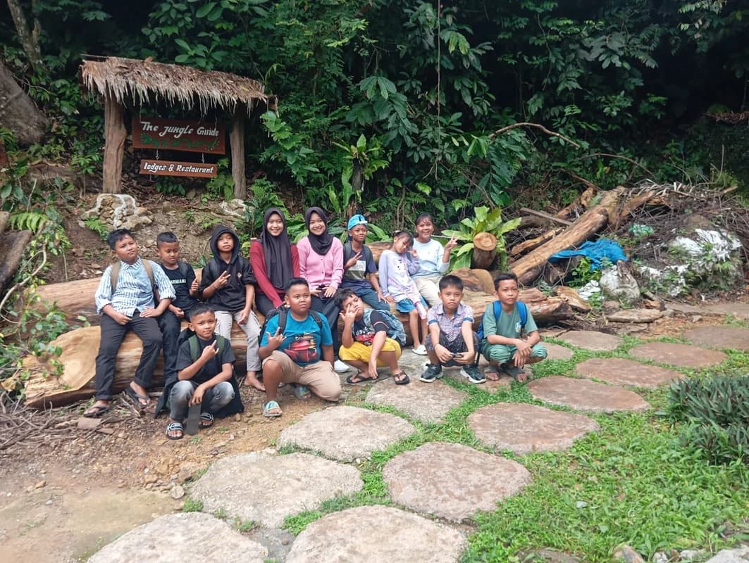 Reizigers in gesprek met lokale Indonesische leerlingen in een klaslokaal in Bukit Lawang